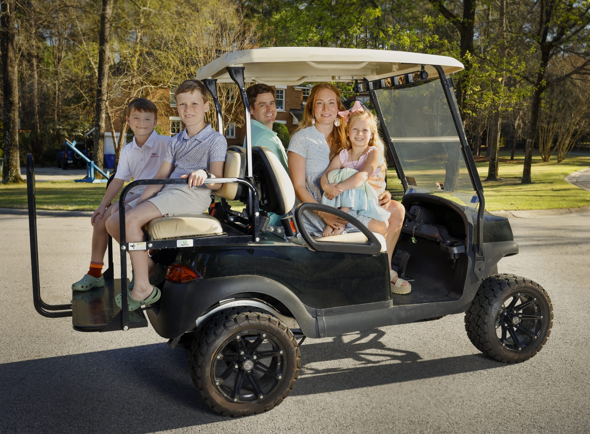 Florida family riding a lifted golf cart through their neighborhood - golf cart insurance Florida coverage from Insurance Specialists